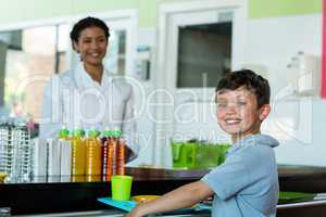 Woman with schoolboy standing at canteen counter