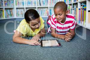 Front view of students reading books while lying at library