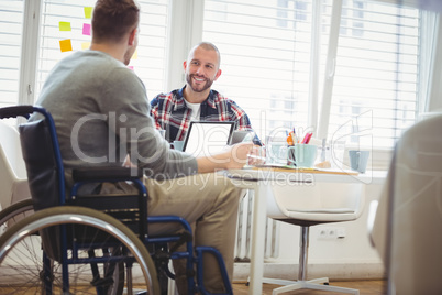 Handicap businessman discussing with colleague in office