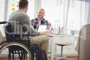 Handicap businessman discussing with colleague in office