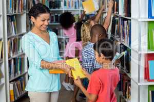 Teacher giving books to boy