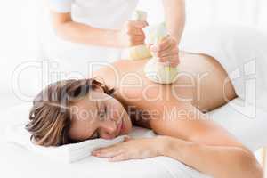 Woman receiving herbal compress massage