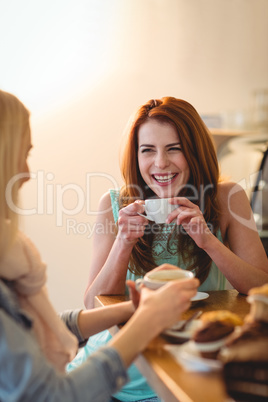 Cheerful woman talking friend at coffee shop