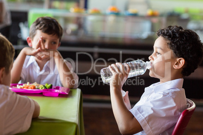 Schoolboy drinking water from bottle