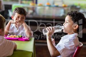 Schoolboy drinking water from bottle