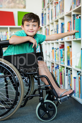Elementary handicapped boy searching books in library