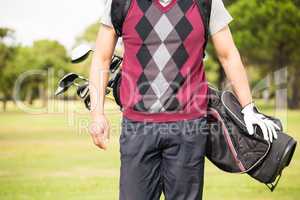 Midsection of man wearing golf bag