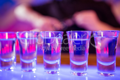 Shot glasses on illuminated bar counter
