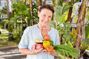 Cheerful woman holding fruits and vegetables