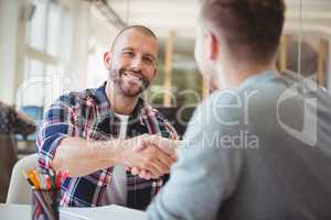 Young business people shaking hands in office