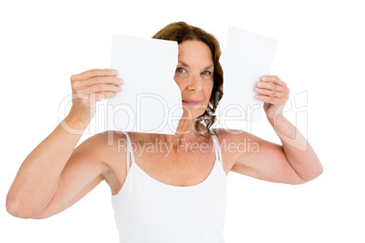 Portrait of mature woman holding torn papers