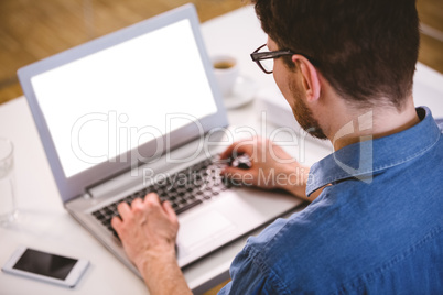 Rear view of executive typing on laptop at creative office