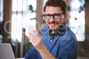 Portrait of confident businessman using mobile phone at office