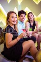 Portrait of joyful friends sitting in nightclub