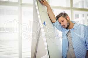 Tired businessman leaning on whiteboard in office