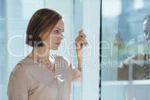 Thoughtful woman standing by glass