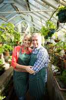 Smiling couple amidst plants at greenhouse