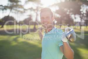 Portrait of happy young man carrying golf club