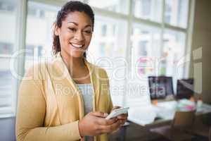 Porrait of young businesswoman using phone at creative office
