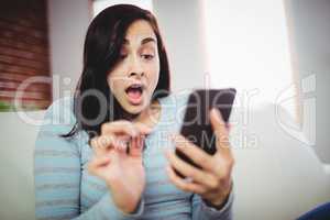 Surprised woman using mobile phone