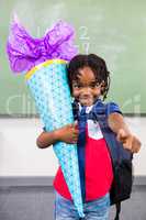 Happy boy holding gift in classroom