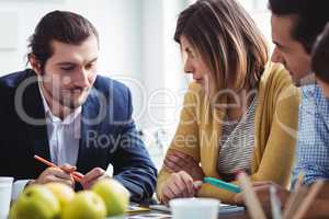 Photo editor explaining to colleagues in meeting room