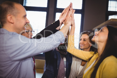 Business people high fiving in creative office
