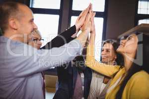 Business people high fiving in creative office