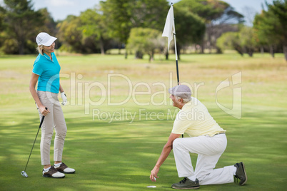 Full length of couple playing golf