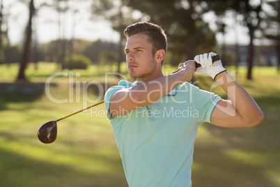 Handsome golfer man taking shot