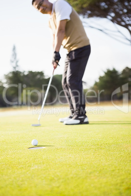 Focus on foreground of golf ball and a hole