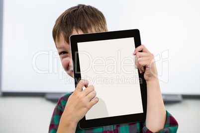 Boy holding digital tablet in classroom