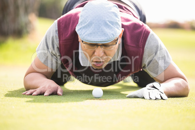 Golfer blowing ball in the hole