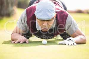 Golfer blowing ball in the hole