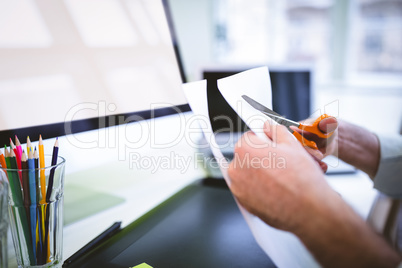 Cropped image of graphic designer cutting paper