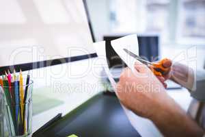 Cropped image of graphic designer cutting paper