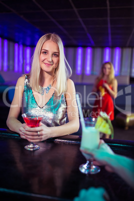 Attractive young woman with cocktail in nightclub