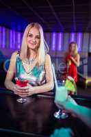 Attractive young woman with cocktail in nightclub