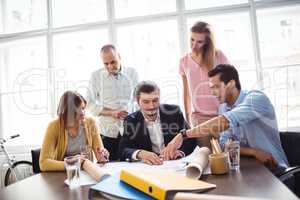 Businessman discussing with coworkers in meeting