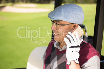 Profile view of golfer smiling and calling