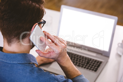 Rear view of businessman talking on cellphone at creative office