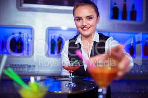 Portrait of bartender serving cocktail