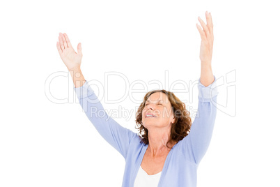 Close-up of mature woman with arms raised while praying