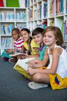 Smiling students sitting at library in school