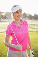 Woman golfer posing with her golf club