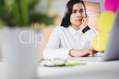 Focused woman working on laptop in office