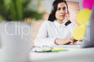 Focused woman working on laptop in office