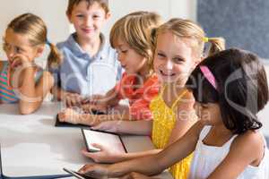 Smiling children using digital tablets