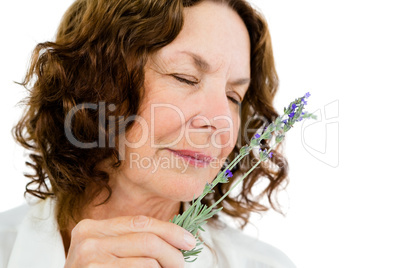Close-up of mature woman smelling flowers