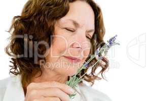 Close-up of mature woman smelling flowers